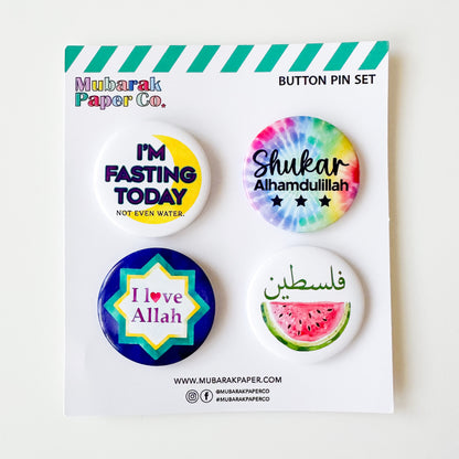 Set of four colorful buttons with text on a Mubarak Paper Co. card.