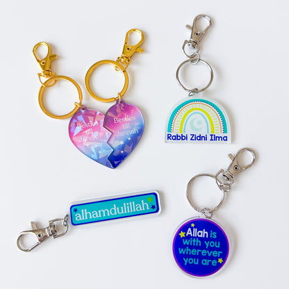 Four colorful keychains with religious text on a white background